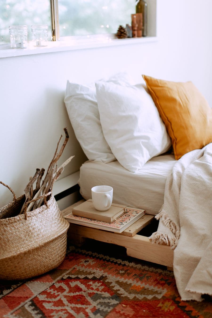 Quarto decorado com roupa de cama e objetos em tons terrosos.