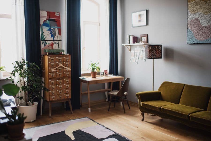 Sala de estar decorada com poltrona e objetos em tons neutros.
