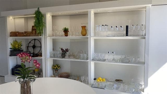 Vitrine de produtos da HOME, com vasos e itens decorativos em tons neutros.